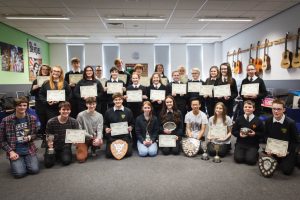 Students holding their trophies / certificates