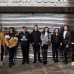 Students outside Law Courts with their winning trophy