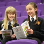 two students sitting with their published book