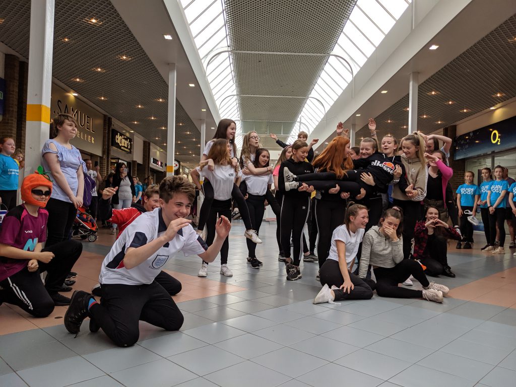 Students performing a dance routine inside a local shopping centre