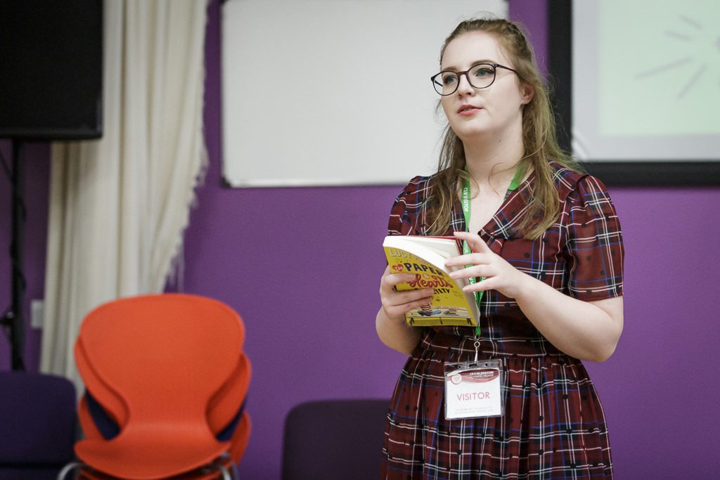 Image of author with her book talking to students