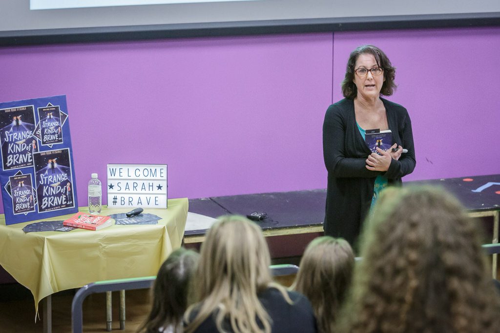 Sarah stands in front of students and talks about her book