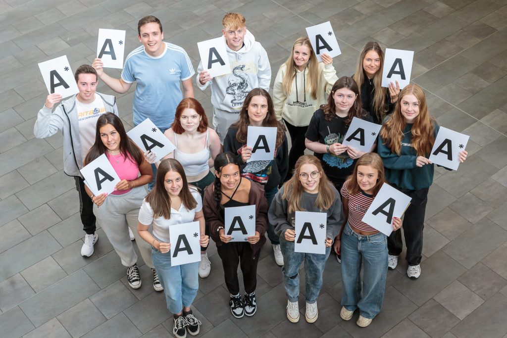 student holding A* signs