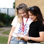 a member of staff with a student looking at their results