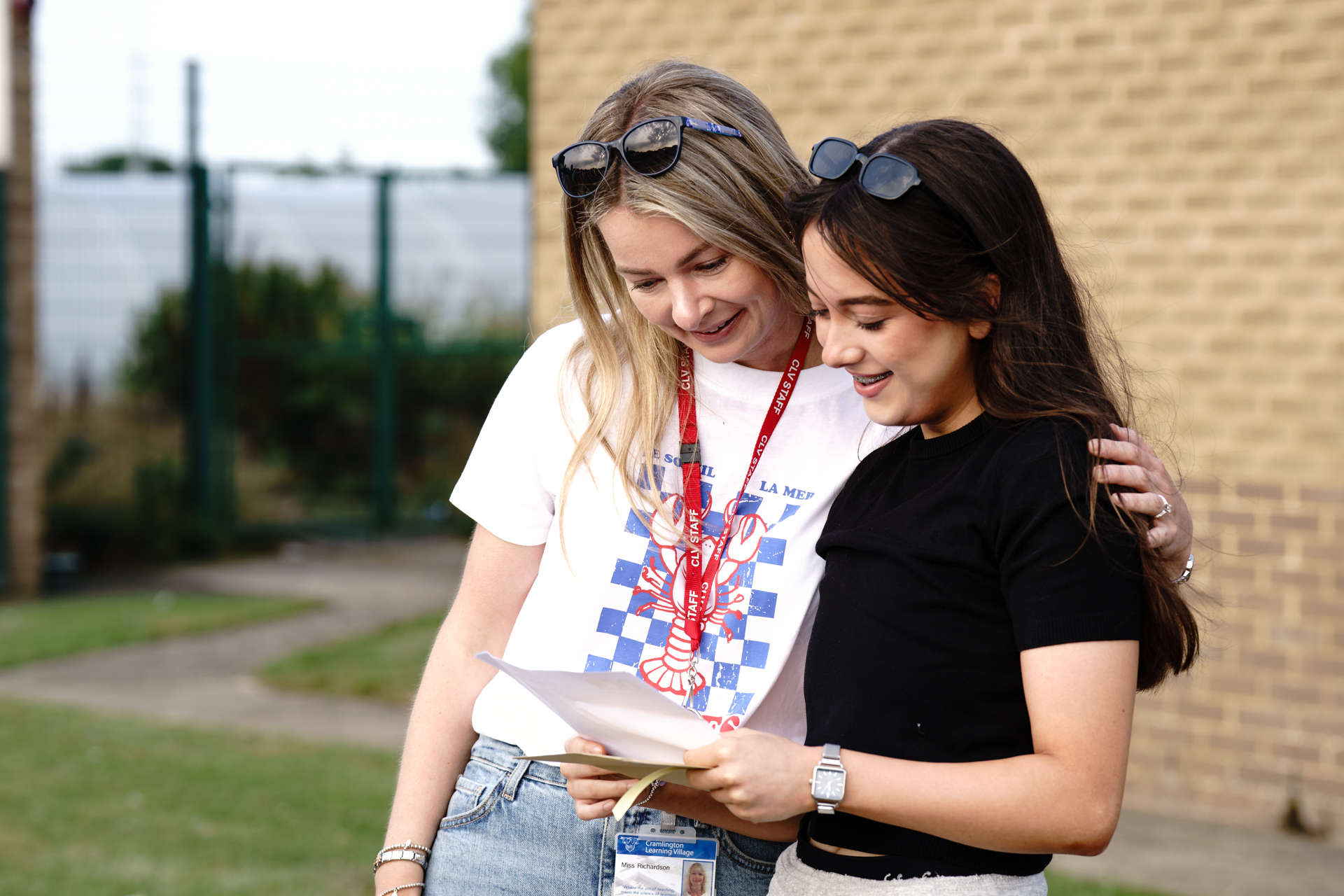 a member of staff with a student looking at their results