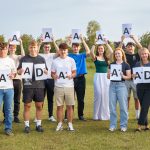 A Level Students holding their A* A and Distinction signs