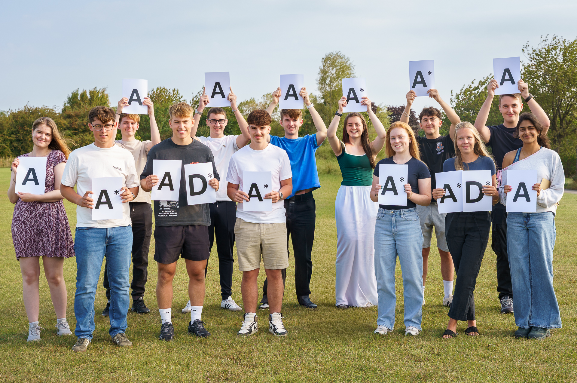 A Level Students holding their A* A and Distinction signs